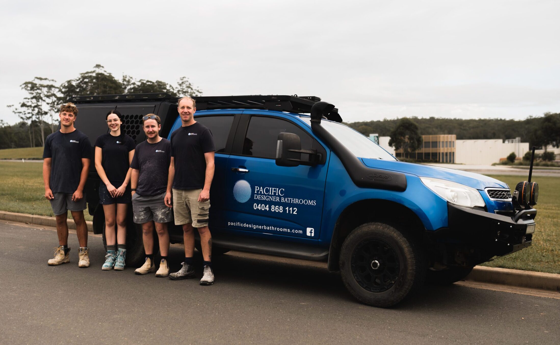 The Pacific Designer Bathrooms team standing in front of a branded work vehicle.